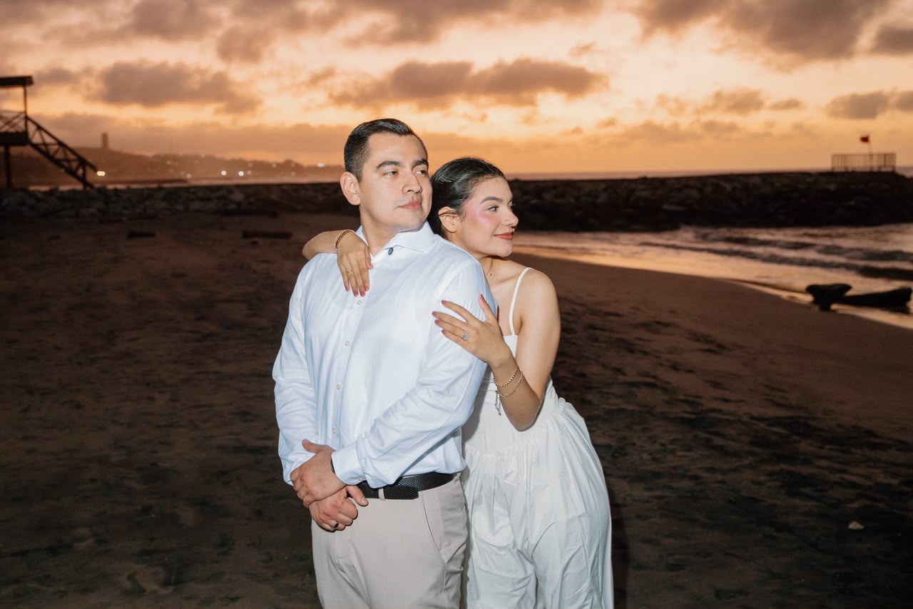 Emily y Franklin abrazados bajo el cielo del atardecer